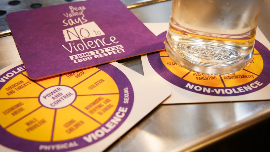 Close up of three coasters with the 1800 RESPECT phone number and an anti-violence graphic