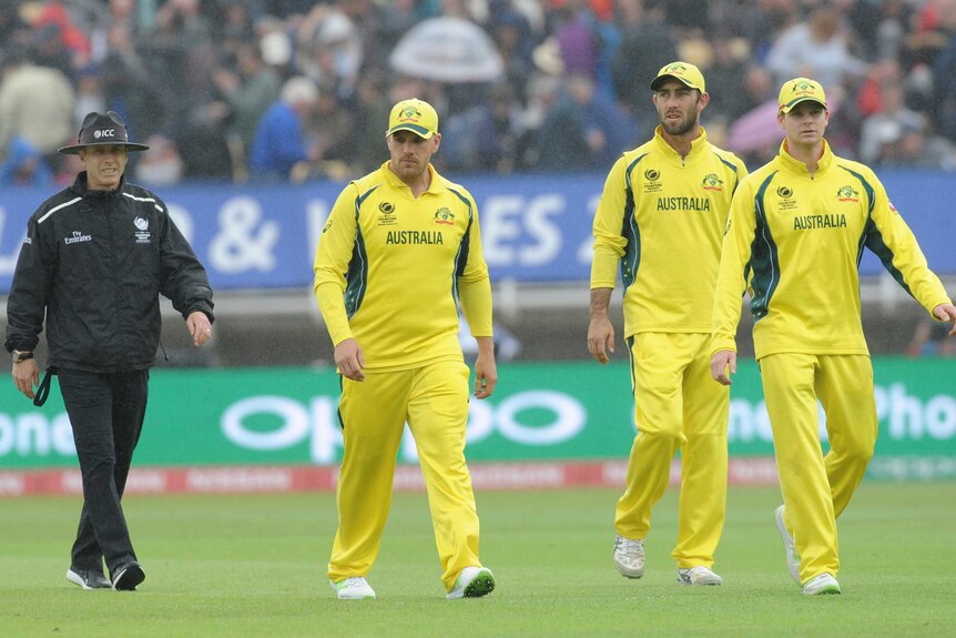 Steve Smith leads Australia off the park as rain falls during the Champions Trophy clash with England