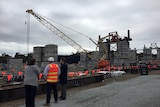 People inspect the construction site where two 180-metre-long bridges will be built.