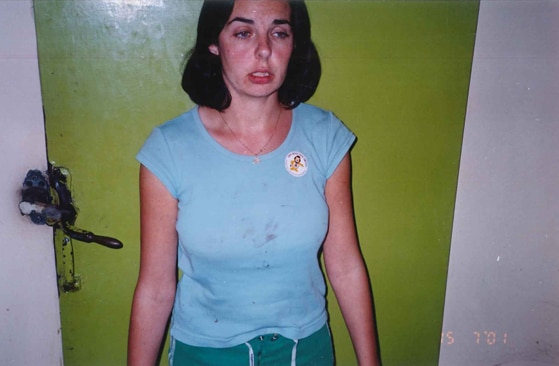 A woman with a brown bob hairstyle and a frightened look on her face wearing a blue shirt 