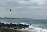 A helicopter flying above the ocean at Bashams Beach