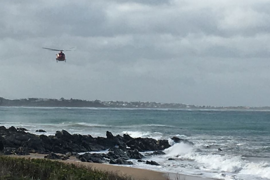 A helicopter flying above the ocean at Bashams Beach