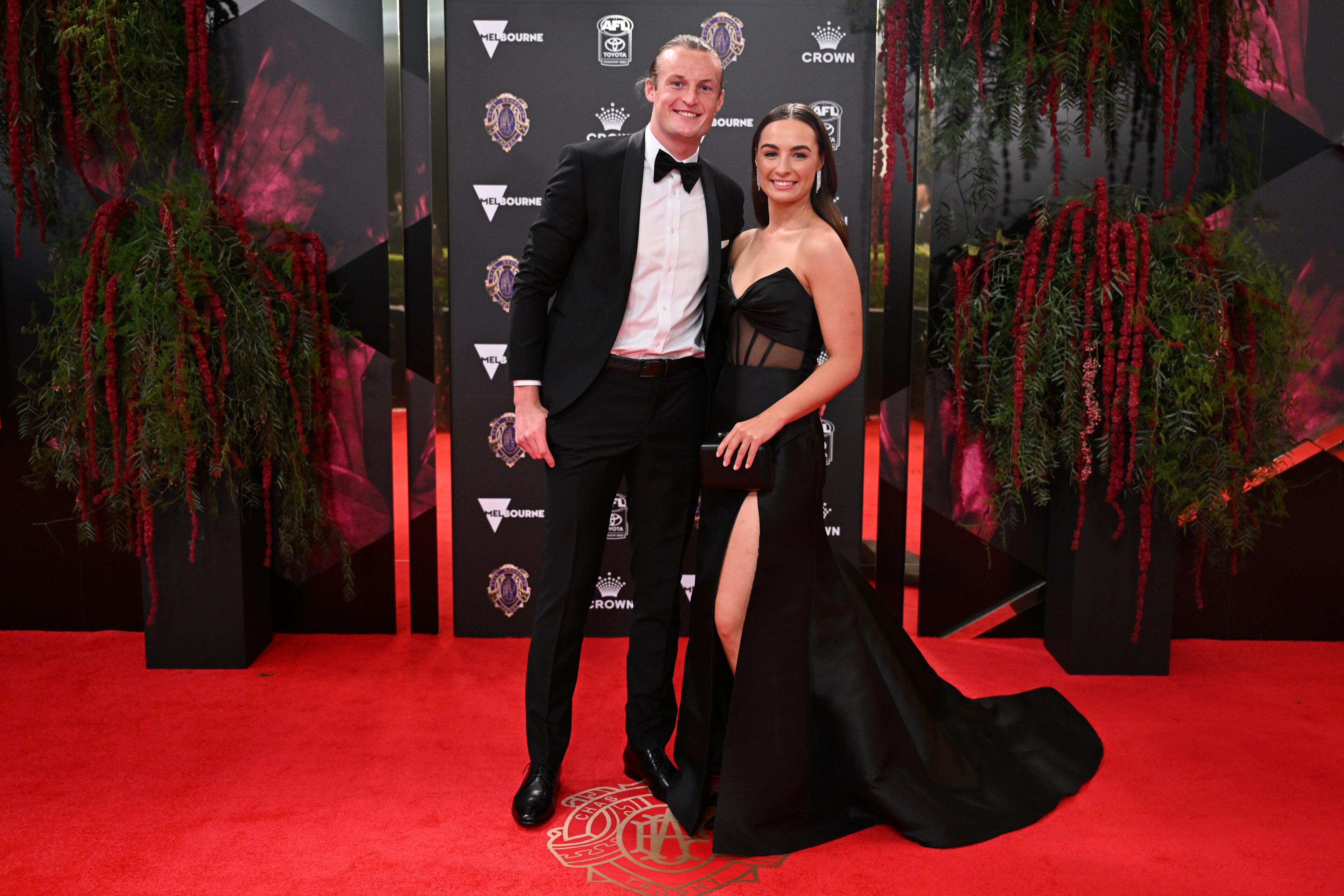 Essendon's Mason Redman and partner Emma Shepard taking black tie very literally