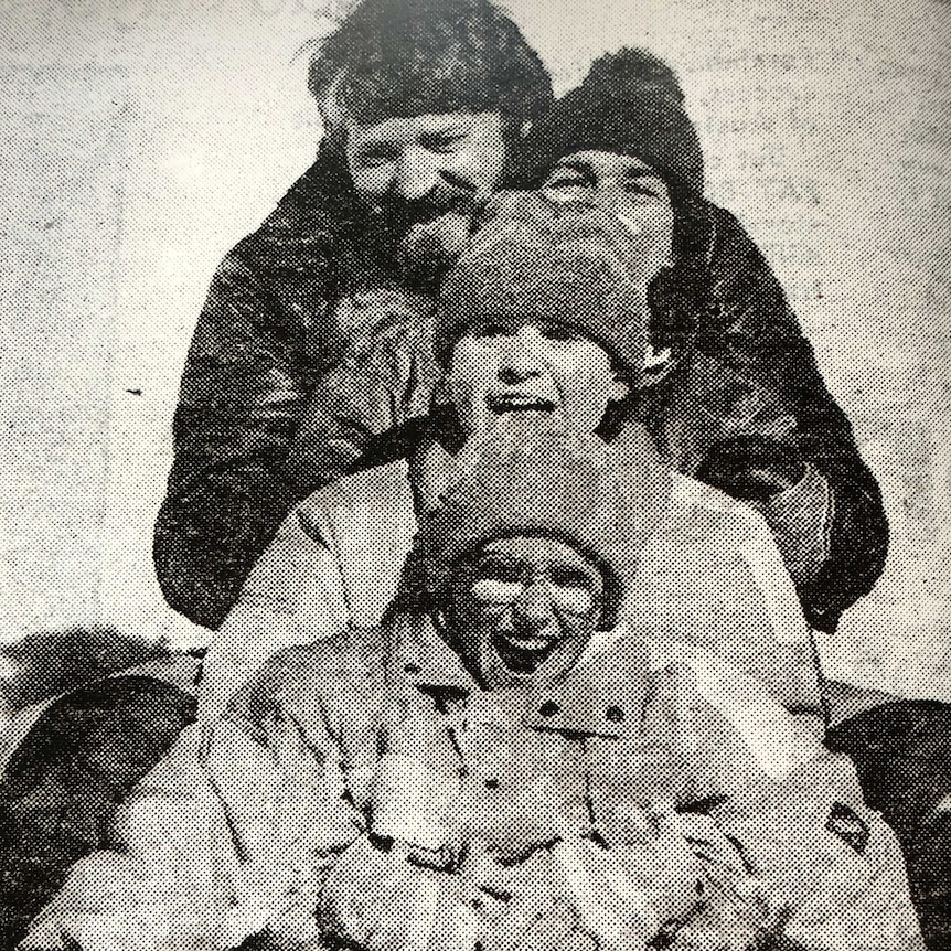 Black and white image of family of four in the snow.