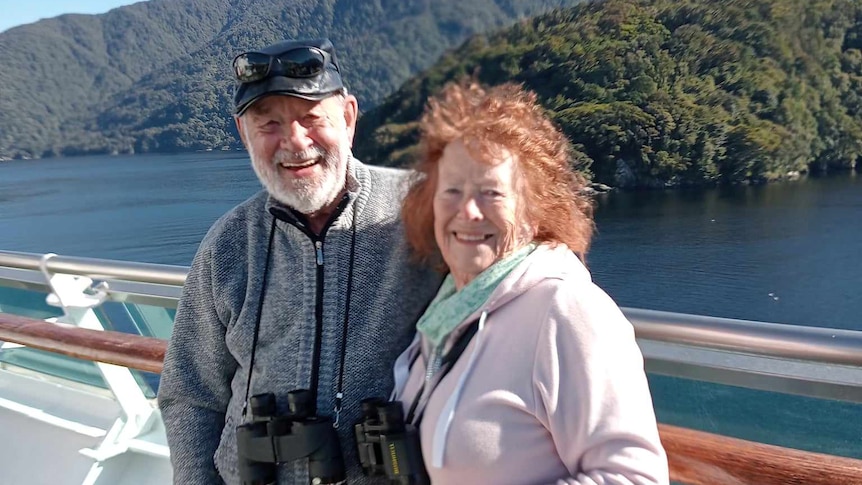 Jane and John Newson, in their 70s, smiles at the camera.