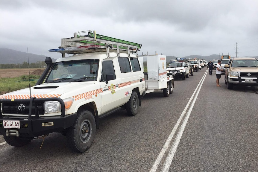Convoy of SES vehicles being let through a roadblock at flooded Sandy Gully after Cyclone Debbie on the Bruce Highway