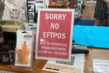 a sign on a checkout desk says 'no eftpos due to technical problems with good old Telstra'