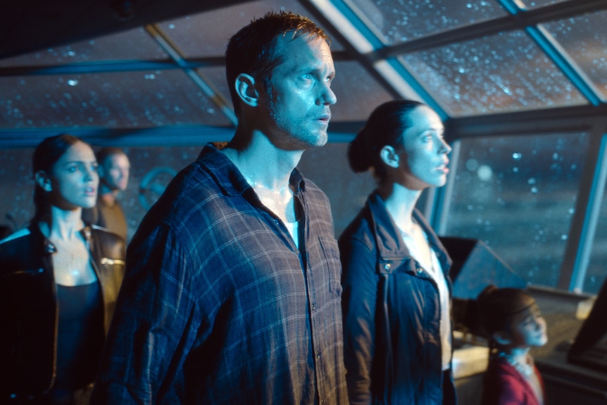 Eiza González, Alexander Skarsgard, Rebecca Hall and Kaylee Hottle standing in a wind-swept ship in Godzilla vs. Kong (2021).