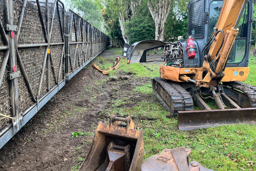 Cane rail bins on a line next to a damaged excavator