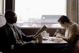 A driver sits in a booth eating breakfast with an African-American classical pianist