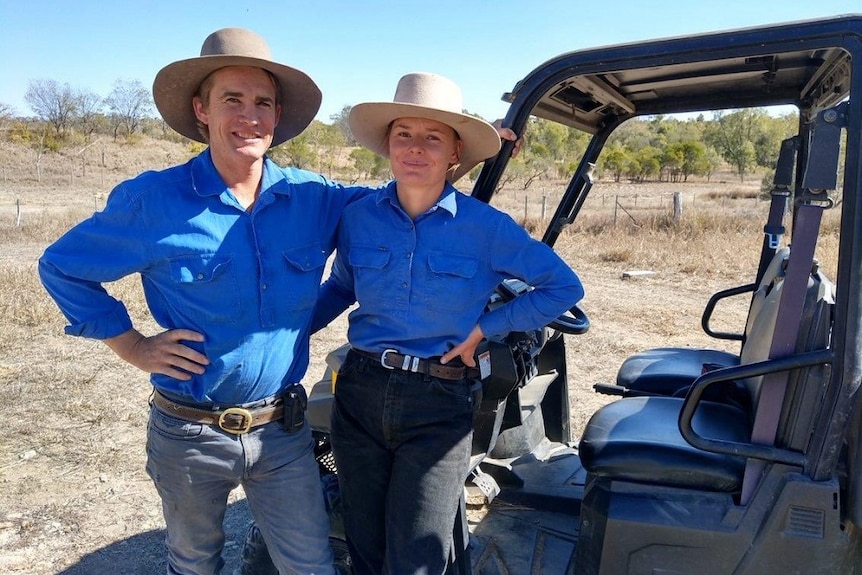 Will and Dorothy Graham stand arm in arm next to a vehicle on the family farm.