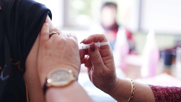 A patient receives a flu shot in the arm