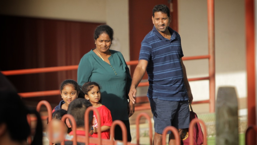 A man and woman with two little girls.