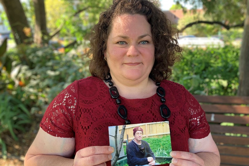 Julie Rickard holds a picture of her partner Steve Bates.