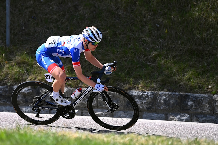 Michael Storer rides his bike wearing a blue and white kit