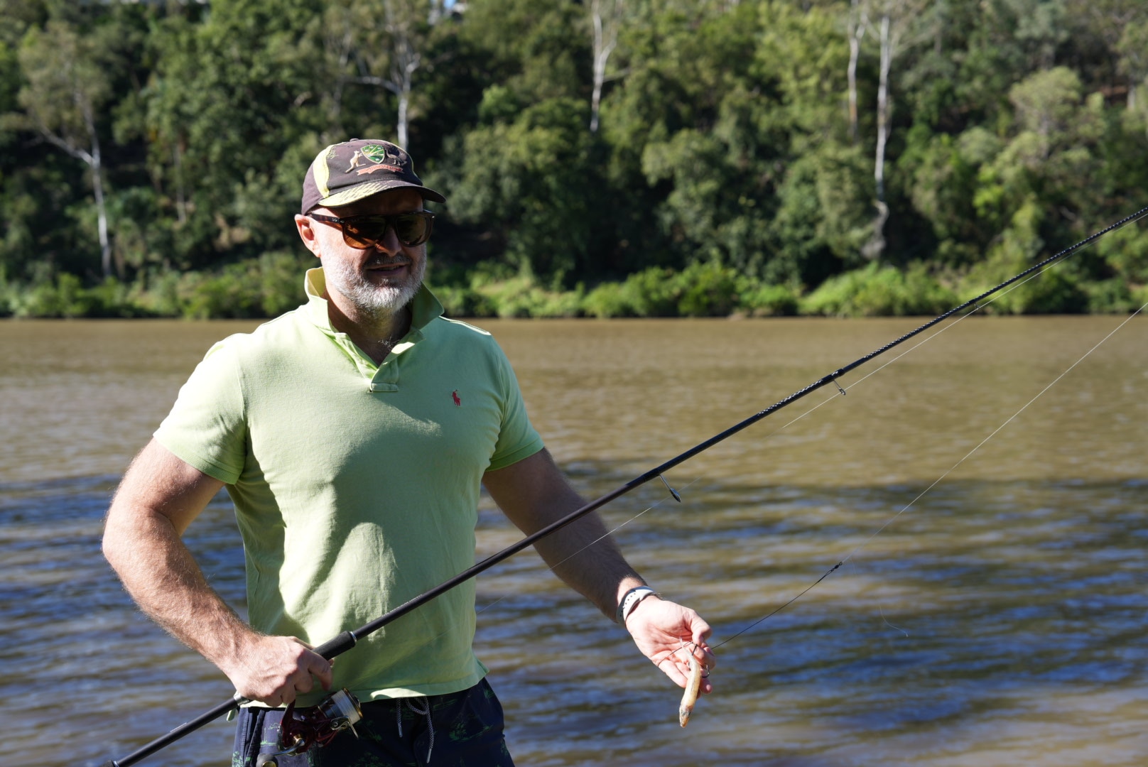 man in a green polo fishing