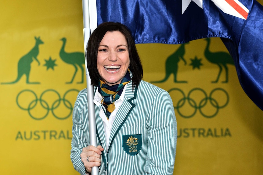 Anna Meares smiles with the Australian flag after being announced as Flag Bearer