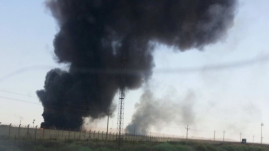 Smoke rises from a oil refinery in Baiji, north of Baghdad.