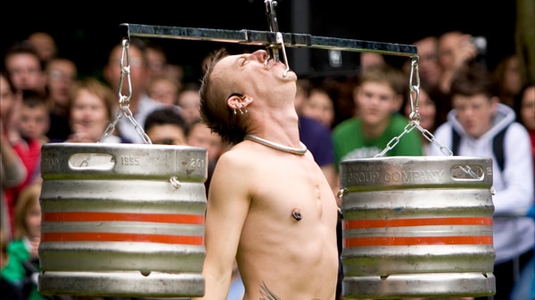 Sword swallowing with two kegs of beer on either side