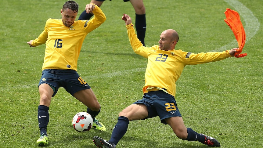 Mark Bresciano (R) challenges for the ball during an Australian Socceroos training session.