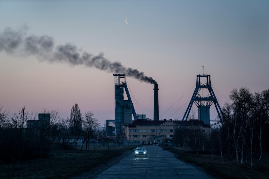 A sunset over an older looking coal plant