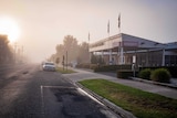 A hospital cloaked in morning fog.