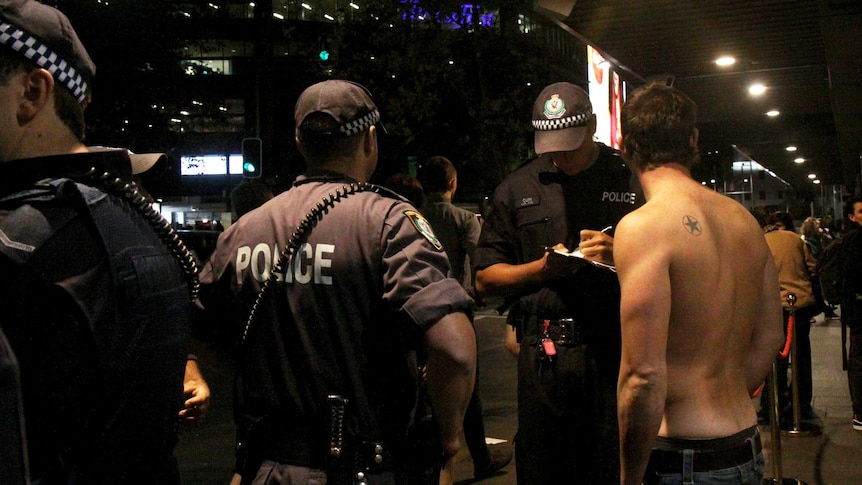 Police speak to a young man in Kings Cross.