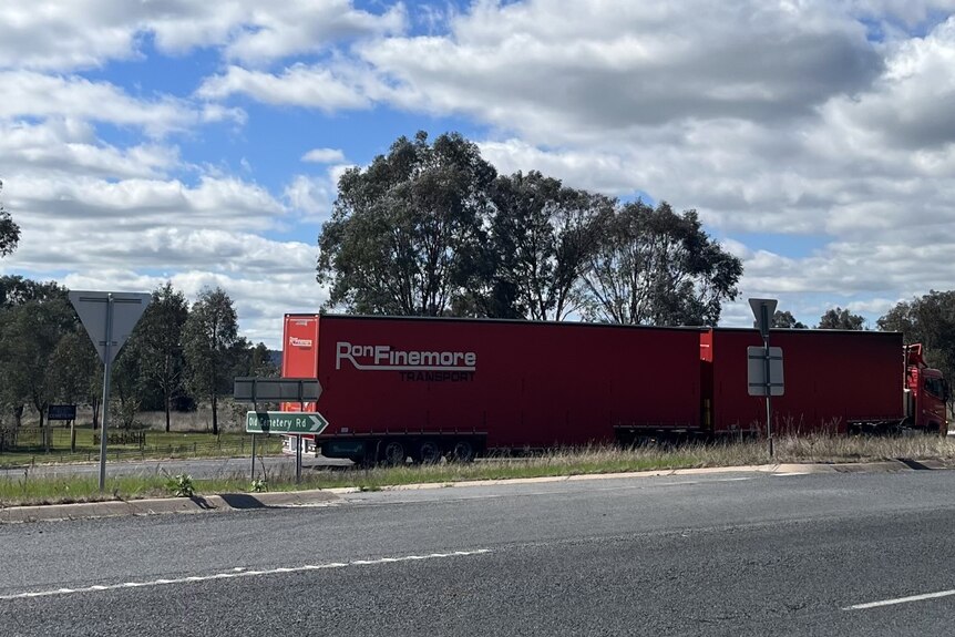 A semitrailer on the side of a freeway in the country.