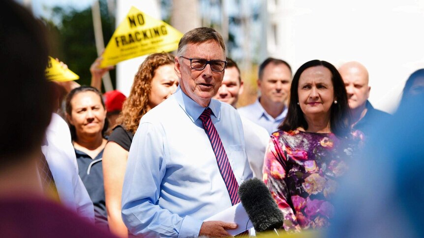 Territory Alliance leader Terry Mills speaks to the media in front of a crowd, some holding "No Fracking" signs