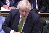 Boris Johnson speaks into a microphone in UK Parliament.