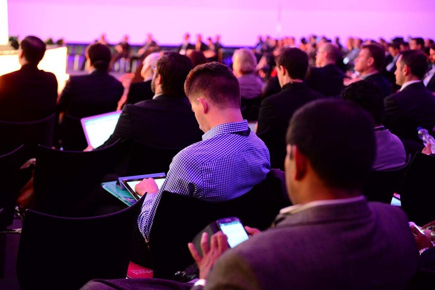 People read their iPads at the Broadband World Forum in Amsterdam.