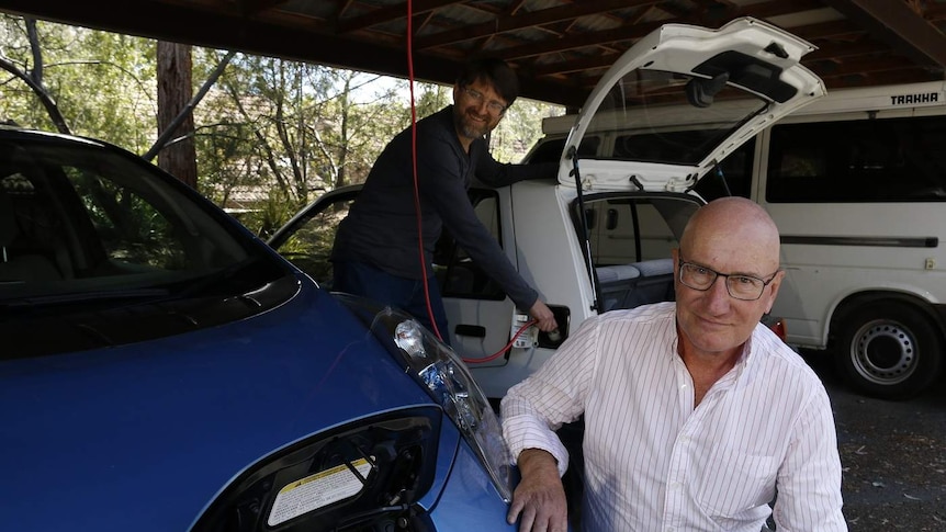 Two men charge their electric cars.