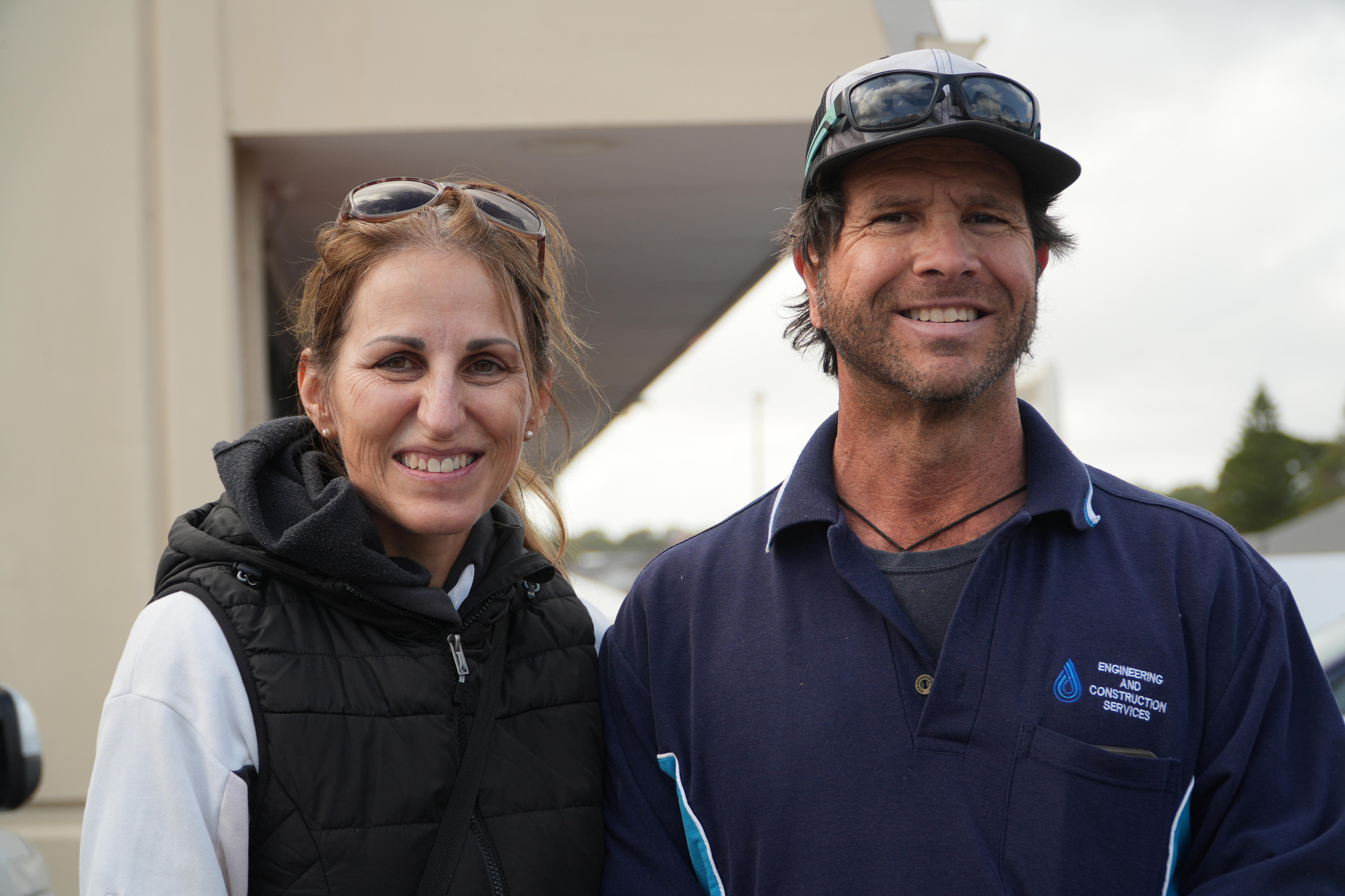 Tiro en la cabeza de una pareja de mediana edad sonriendo a la cámara.