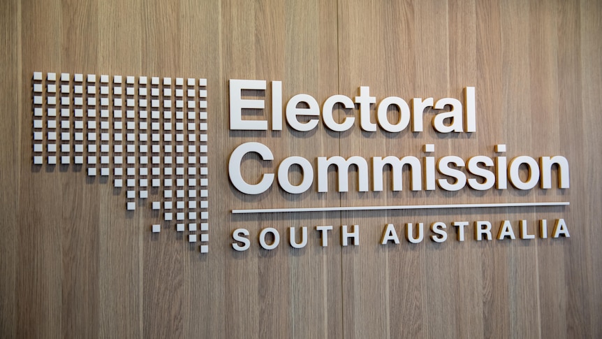 The logo of the Electoral Commission of South Australia on a brown wall