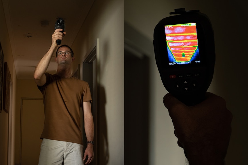 A man holds a thermal imaging camera towards the ceiling of his home.