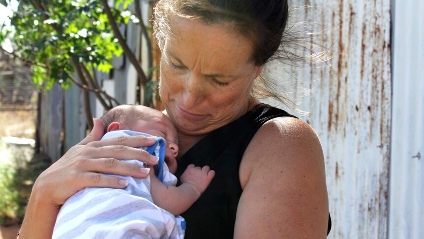 woman holding newborn baby to her chest