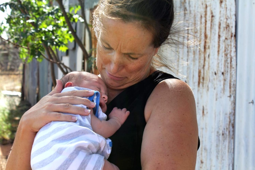 woman holding newborn baby to her chest
