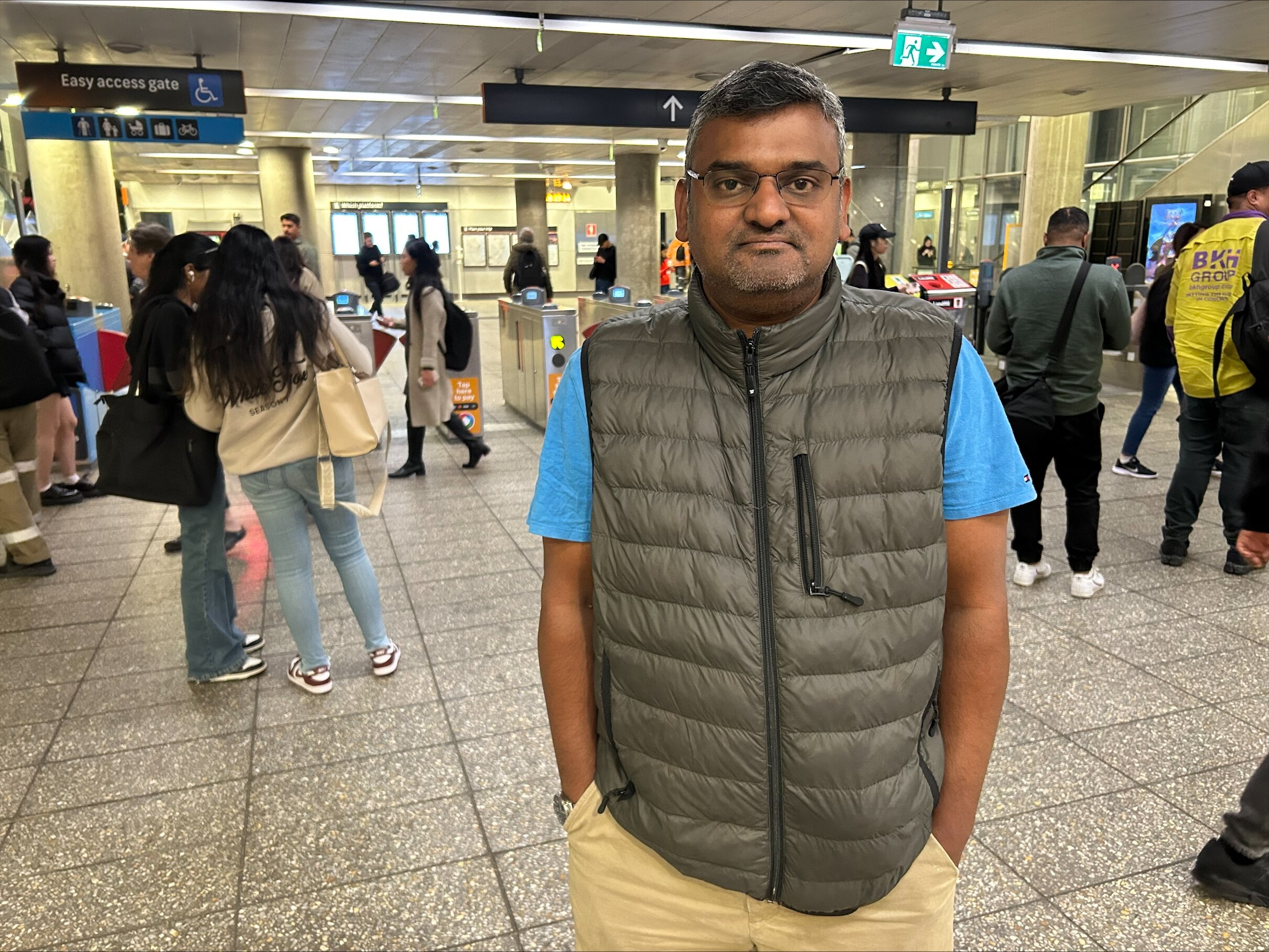 Un hombre mediano se ve frustrado mientras se encuentra en una estación de tren interior.