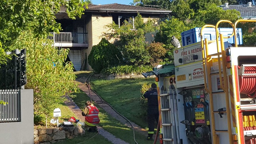 Firefighters outside an Everton Hills home in which three people died when a fire broke out.