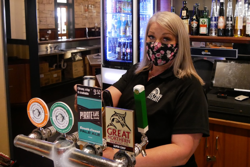 woman pours beer at pub
