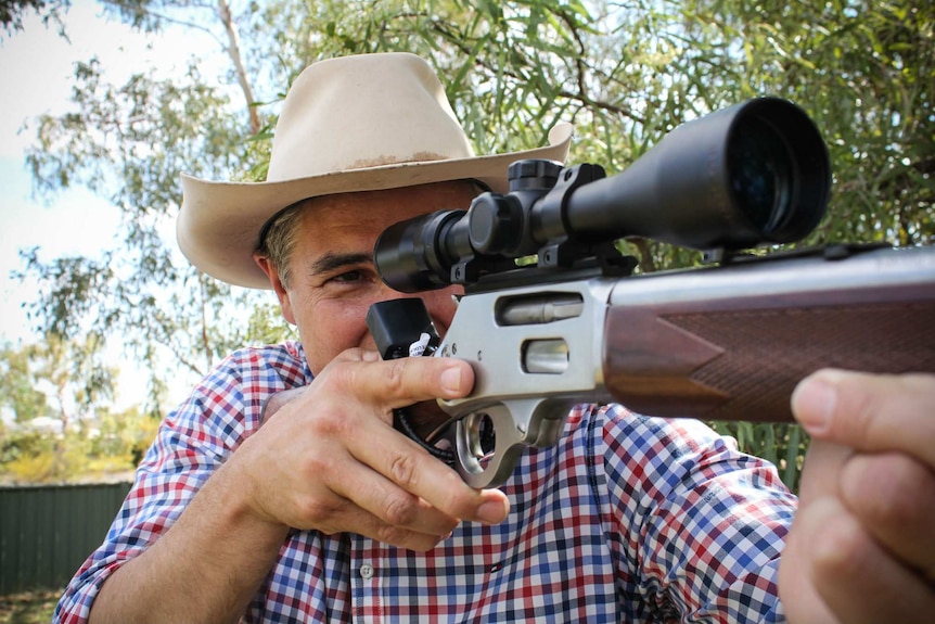 Robbie Katter pretends to aim a rifle