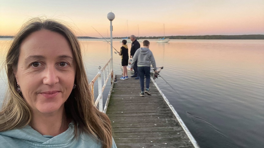 Amanda takes a selfie with her family in the background in a story about home and contents insurance.