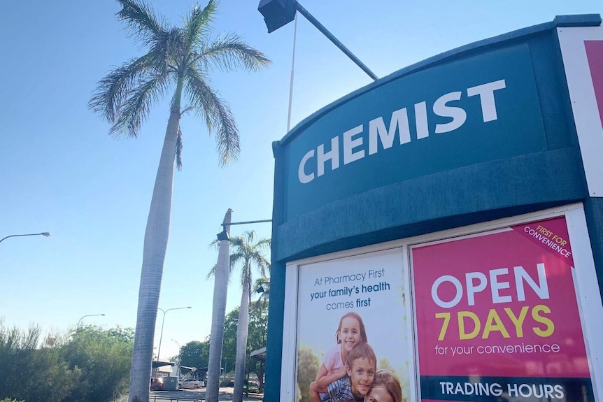 A sign out the front of a chemist on a sunny day.