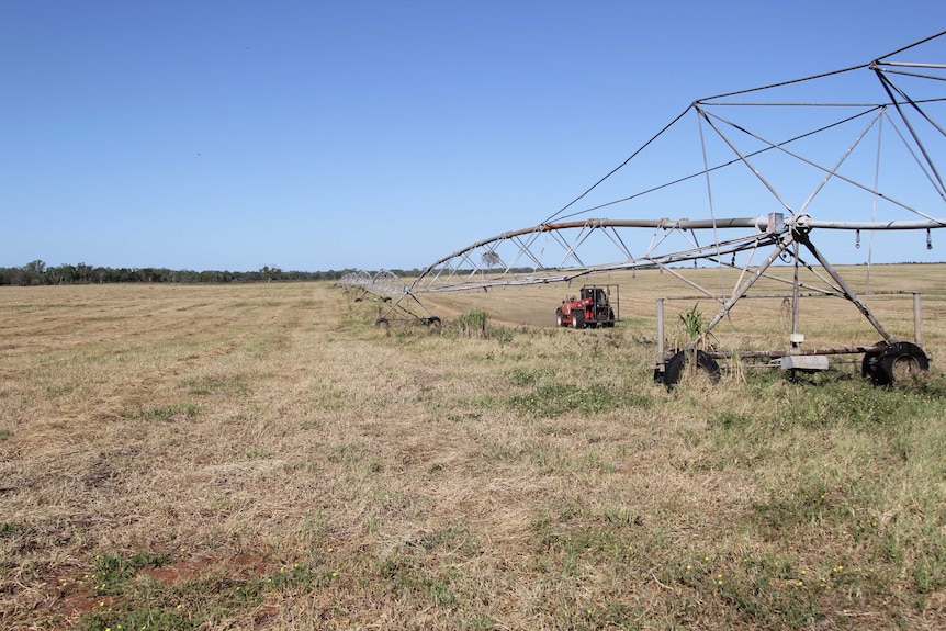 a centre-pivot with a tractor in the background