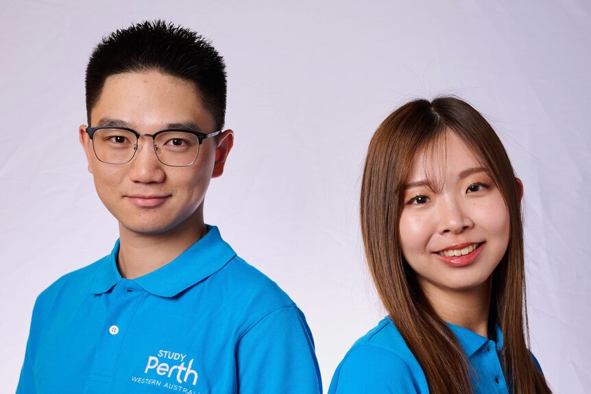 Two international students next to each other wearing a blue polo.