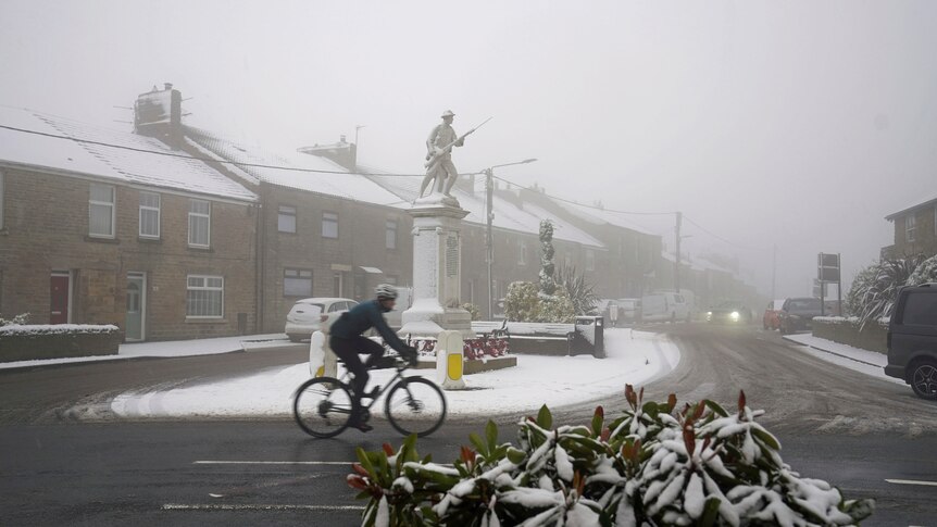 A cyclist rides through snowy conditions 