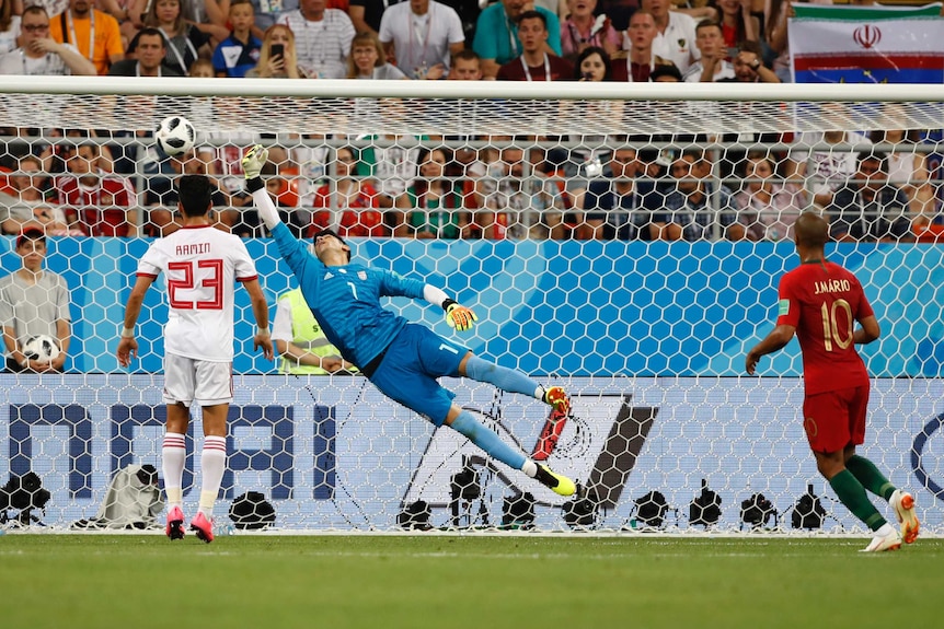 Iran's goalkeeper can't reach a shot by Portugal