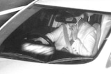 black and white photo of woman using phone while driving