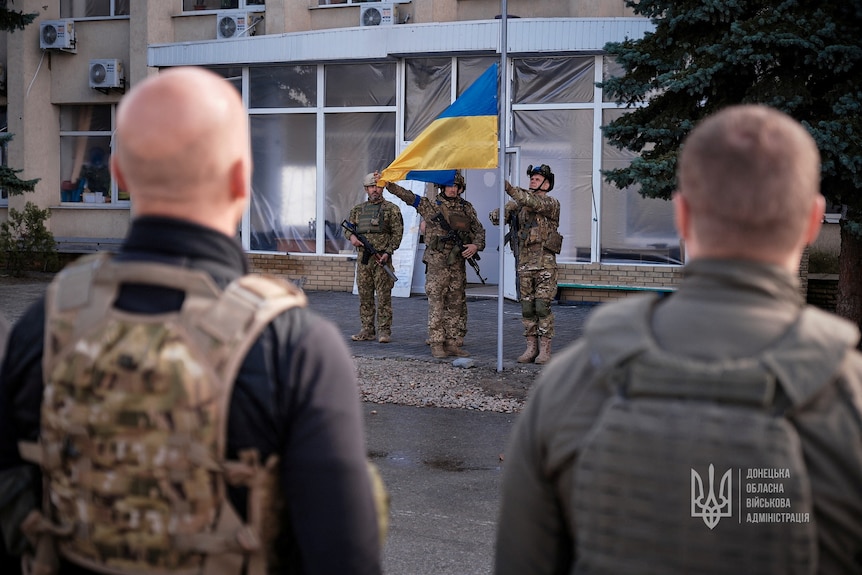 Ukraine soldiers raise flag in liberated town of Lyman. 