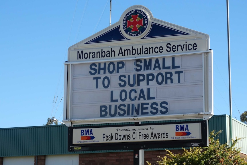 An sign outside an ambulance station encourages people to support local business.